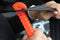 Car safety tool in emergency breaks glass and cuts seat belt if trapped. Seat belt cutter shown.